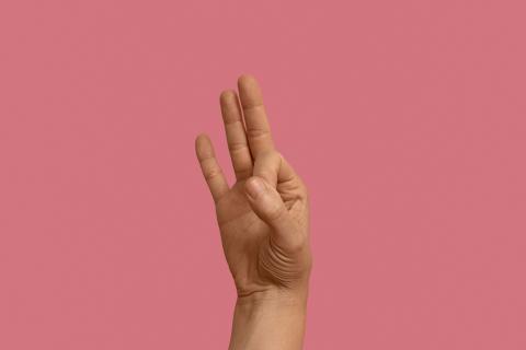 Gest języka migowego na różowym tle